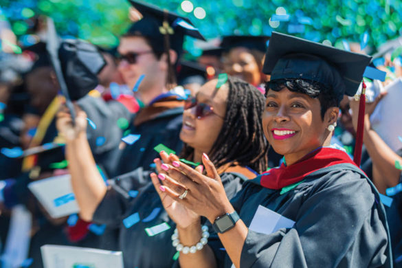 A Regent University graduate claps during the commencement ceremony in Virginia Beach.