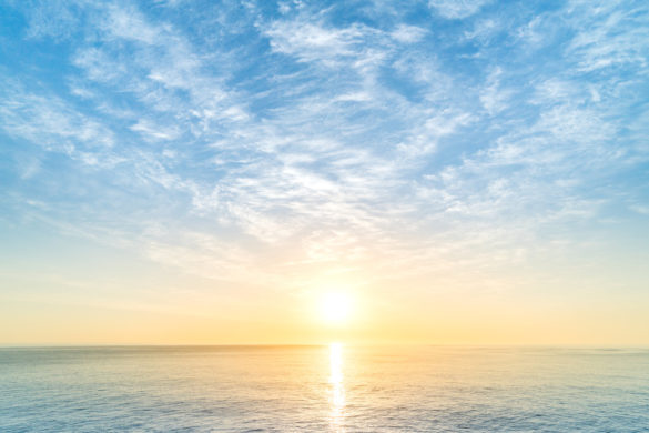 A view of the sky, sun and sea, with sunlight reflected on the water.