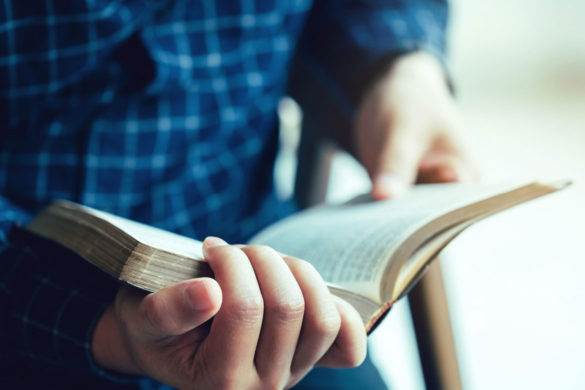 close up of hands holding a bible