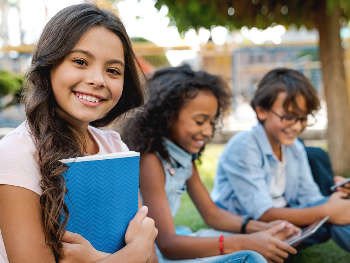 school kids smiling and holding books